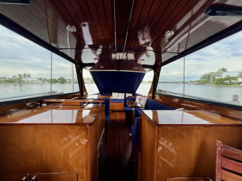 Slide: The Image of Interior of 2013 Custom O'Neill Craft Tritoon boat with polished wood finish and blue seating. - 10