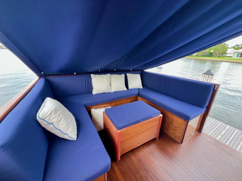 Slide: The Image of Luxurious seating area on 2013 Custom O'Neill Craft Tritoon with blue cushions and wooden accents. - 17