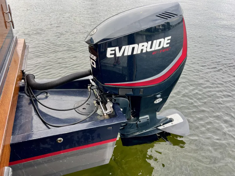 Slide: The Image of Evinrude E-TEC outboard motor on 2013 O'Neill Craft Tritoon boat in water. - 25