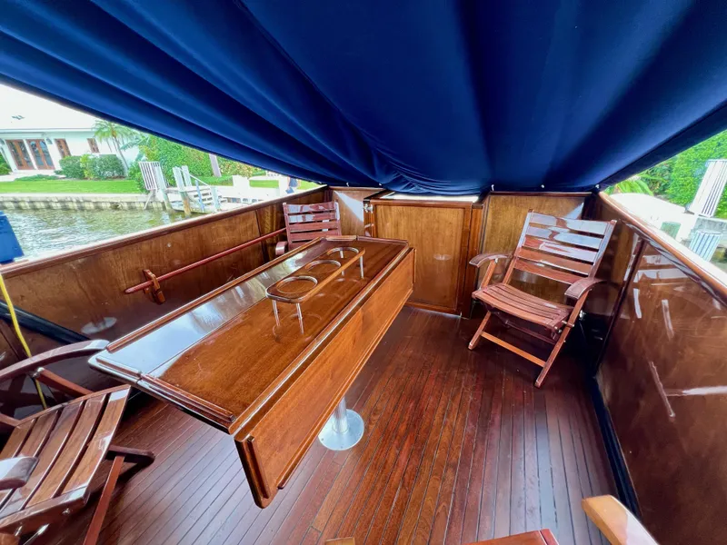 Slide: The Image of Luxurious 2013 Custom O'Neill Craft Tritoon interior with wooden seating and table under blue canopy. - 8