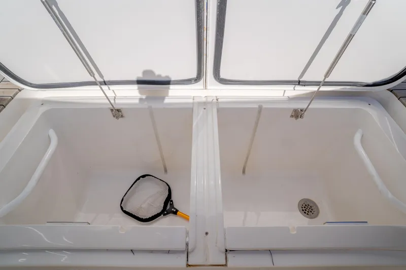 Slide: The Image of Open storage compartments on 2017 Viking 48 Convertible boat with a fishing net inside. - 22