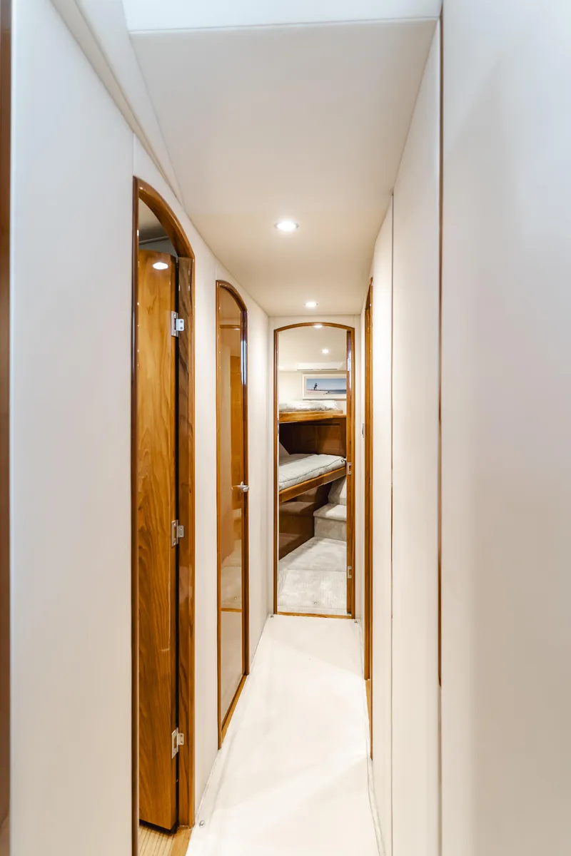 Slide: The Image of Interior hallway of 2017 Viking 48 Convertible yacht with wooden doors and modern lighting. - 29
