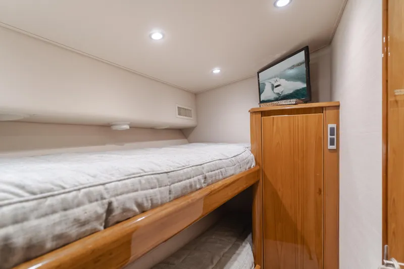 Slide: The Image of Cozy cabin interior of 2017 Viking 48 Convertible yacht with bunk beds and TV. - 35