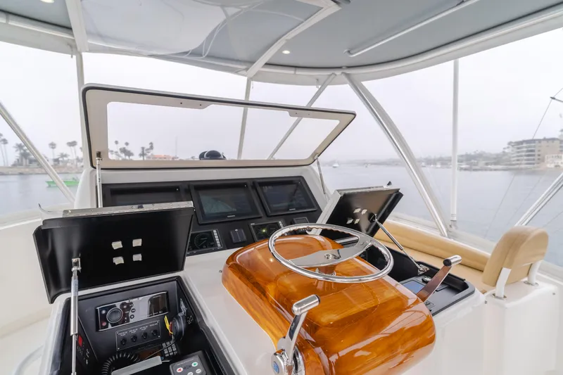 Slide: The Image of 2017 Viking 48 Convertible yacht helm with modern navigation equipment and steering wheel. - 8