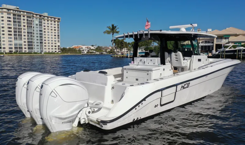 Slide: The Image of 2022 HCB 42 Lujo boat with triple engines on a sunny waterfront. - 12
