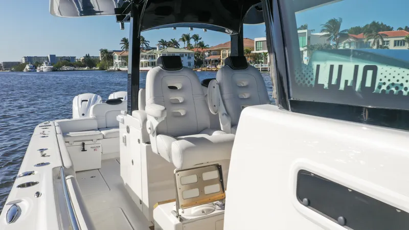 Slide: The Image of 2022 HCB 42 Lujo boat interior with luxurious seating on a sunny waterfront. - 26