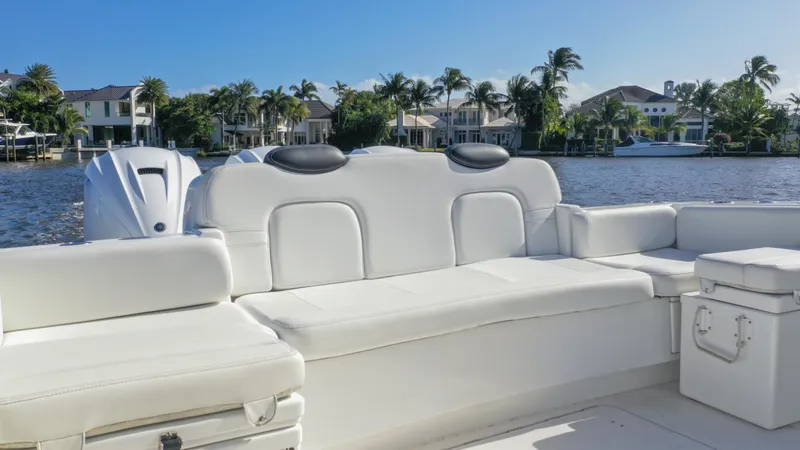 Slide: The Image of 2022 HCB 42 Lujo boat with white seating, docked by waterfront homes. - 29