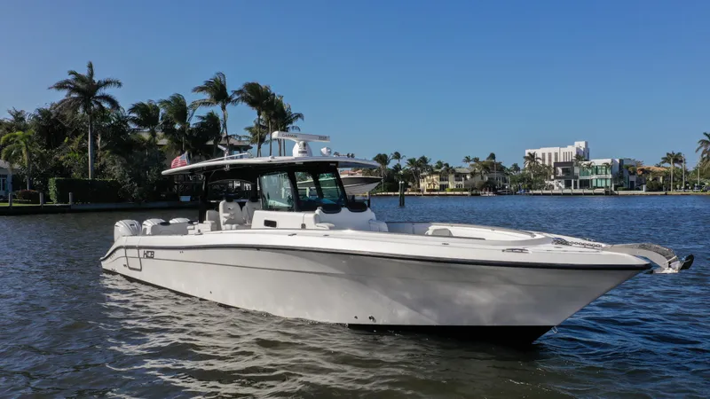 Slide: The Image of 2022 HCB 42 Lujo boat on a sunny waterfront with palm trees. - 3