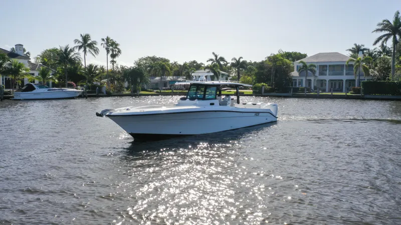 Slide: The Image of 2022 HCB 42 Lujo boat cruising on a sunny waterfront with palm trees. - 4