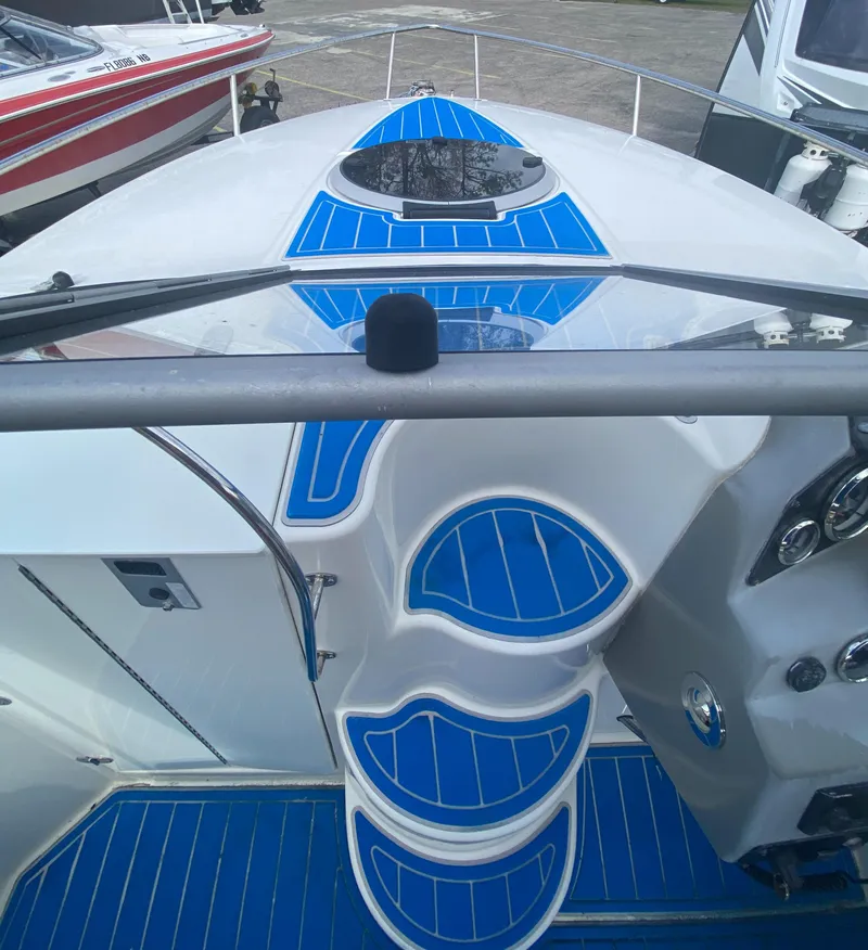 Slide: The Image of 2019 Stingray 250CR boat with blue deck accents, docked alongside other vessels. - 12