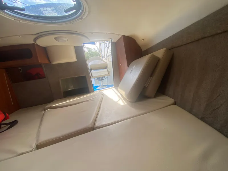 Slide: The Image of Interior cabin of a 2019 Stingray 250CR boat with beige cushions and a small window. - 4