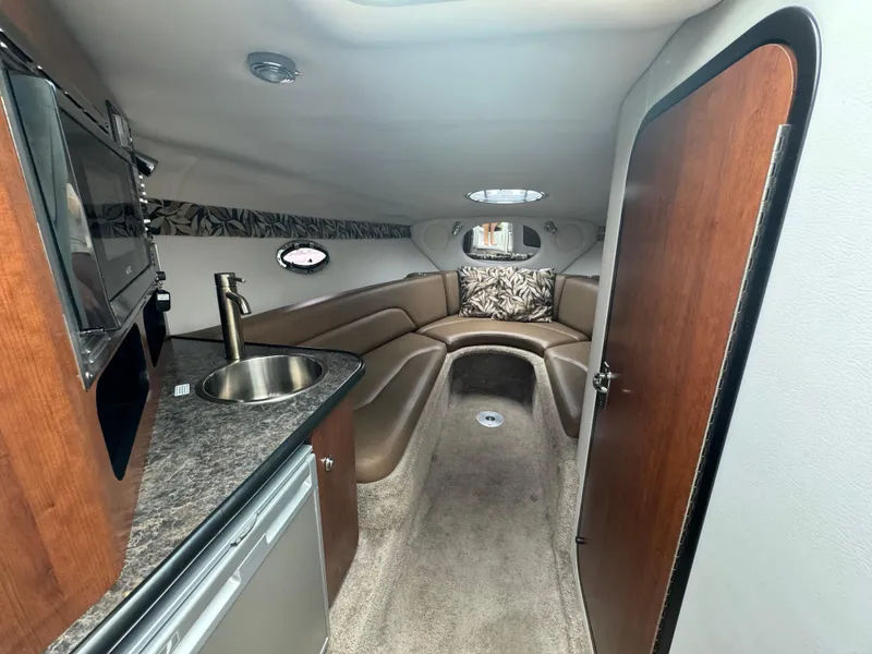 Slide: The Image of 2020 Crownline 286 SC cabin interior with kitchenette and seating area. - 10
