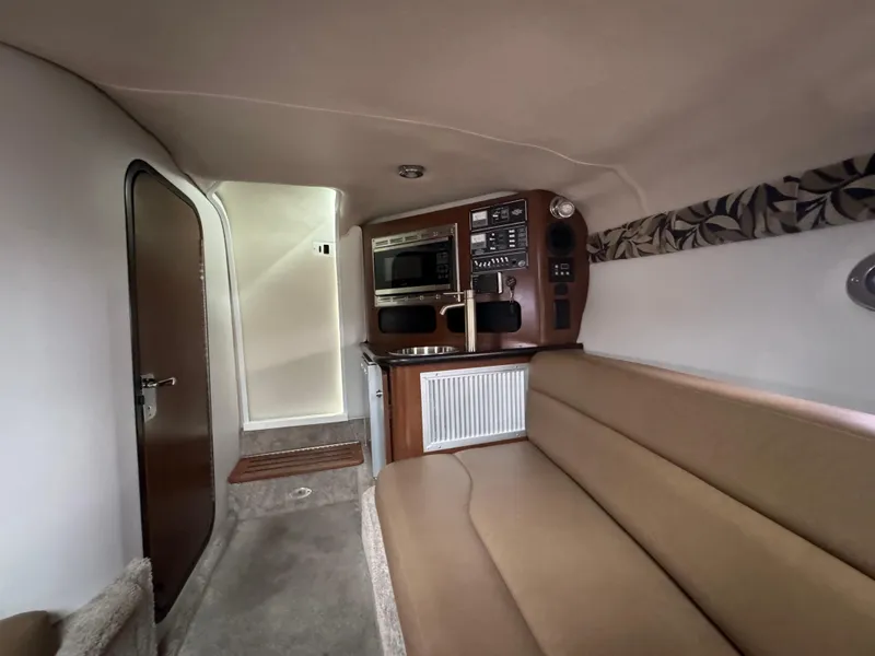 Slide: The Image of Interior of 2020 Crownline 286 SC boat with beige seating and kitchenette. - 13