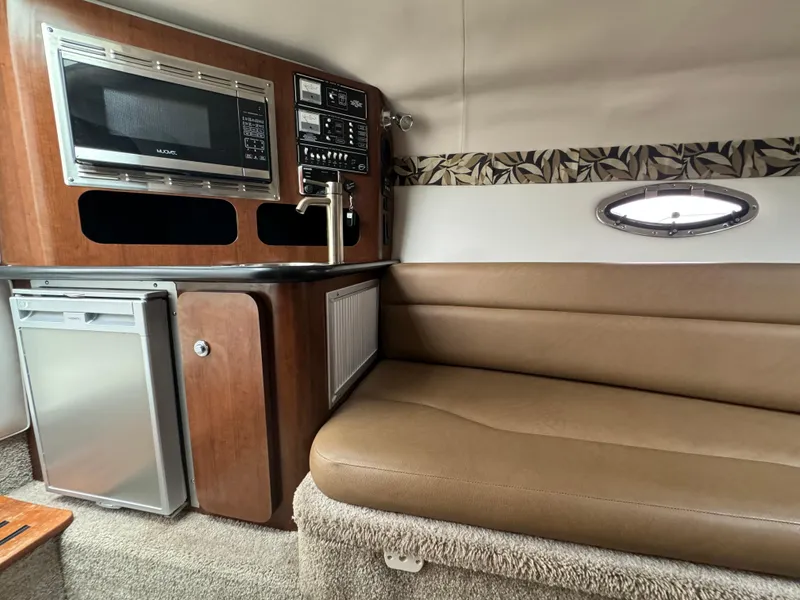 Slide: The Image of 2020 Crownline 286 SC cabin interior with kitchenette and seating area. - 14