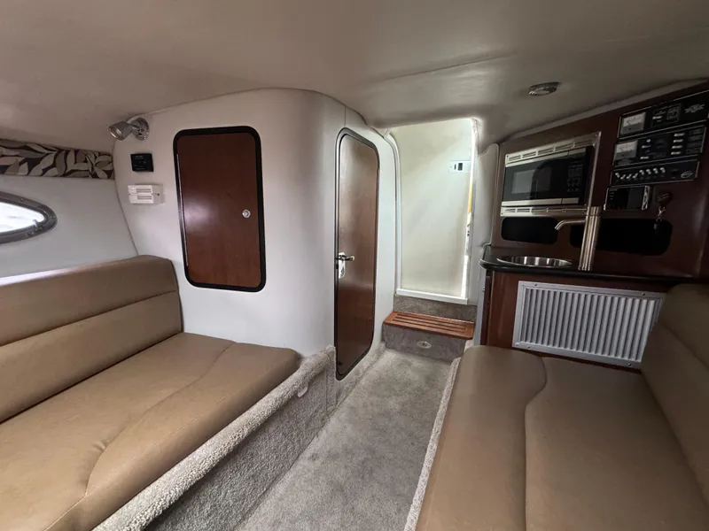 Slide: The Image of Interior of 2020 Crownline 286 SC boat with beige seating and kitchenette. - 15
