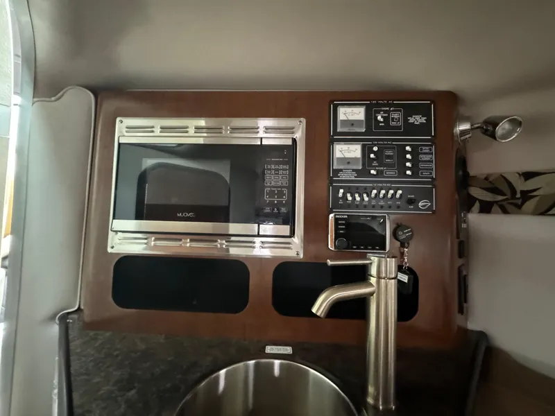 Slide: The Image of 2020 Crownline 286 SC boat interior with microwave and control panel. - 16