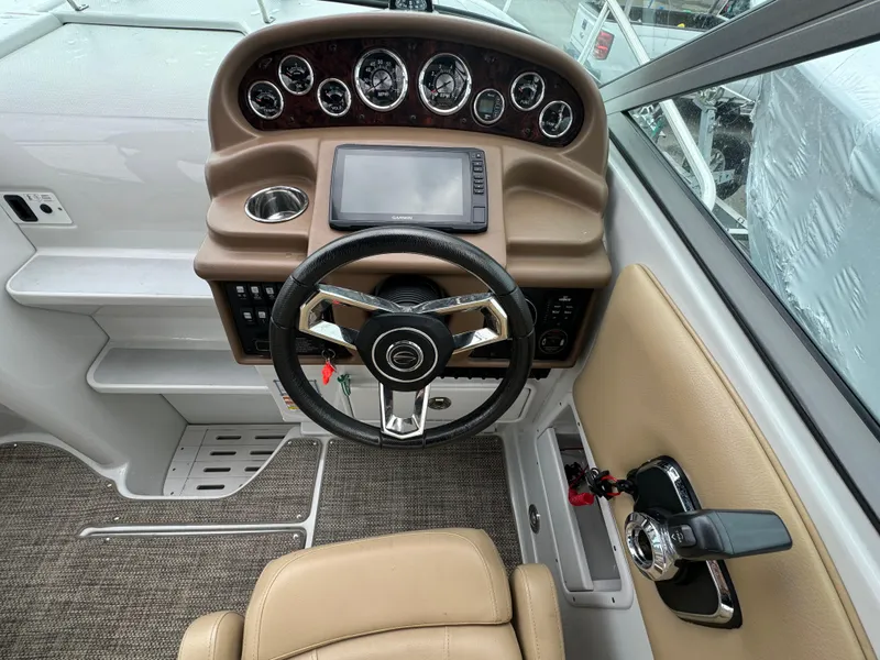 Slide: The Image of 2020 Crownline 286 SC boat dashboard with steering wheel and control panel. - 6