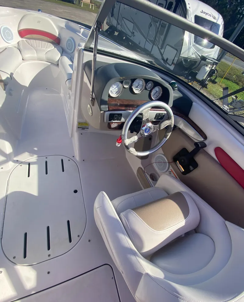 Slide: The Image of 2006 Four Winns 210 Horizon boat interior with steering wheel and seating. - 13