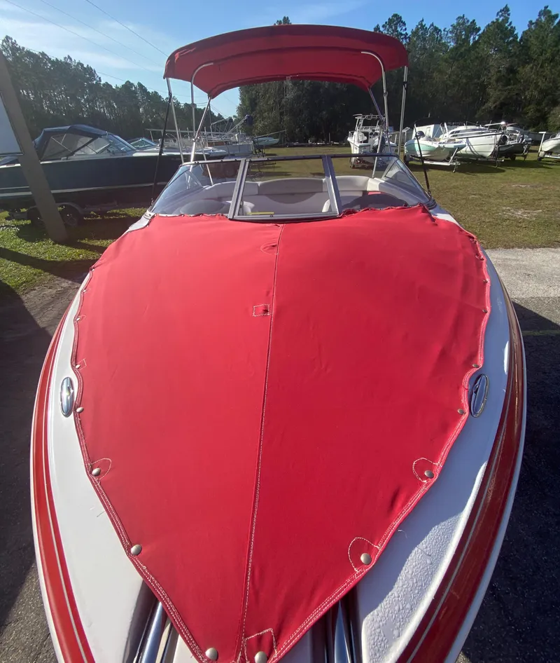 Slide: The Image of 2006 Four Winns 210 Horizon boat with red cover and canopy, parked outdoors. - 9