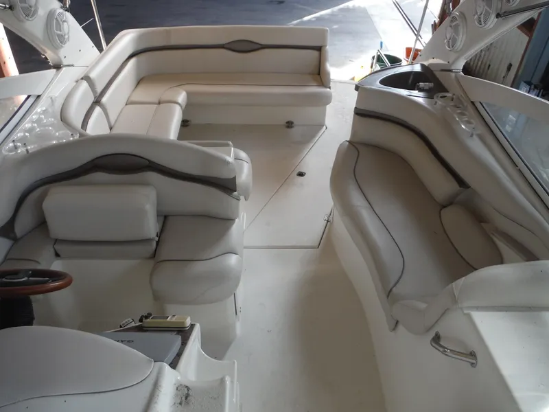 Slide: The Image of 2002 Doral 310se boat interior with white leather seating and steering area. - 19