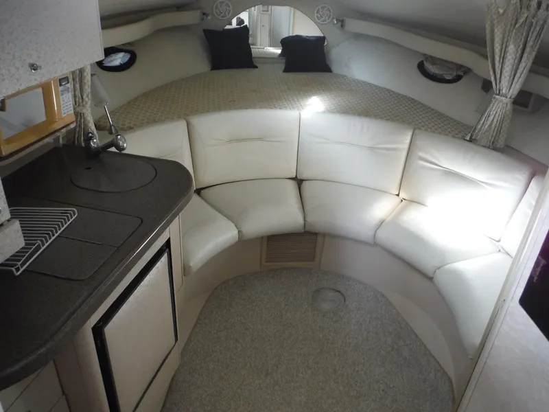 Slide: The Image of Interior of 2002 Doral 310se boat with white seating and compact kitchen area. - 20