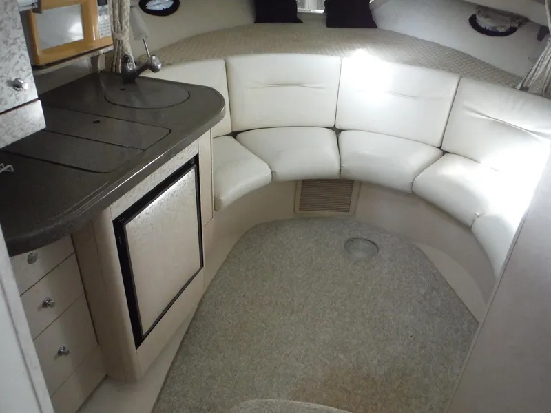 Slide: The Image of Interior of 2002 Doral 310se boat with white seating and compact kitchenette. - 31