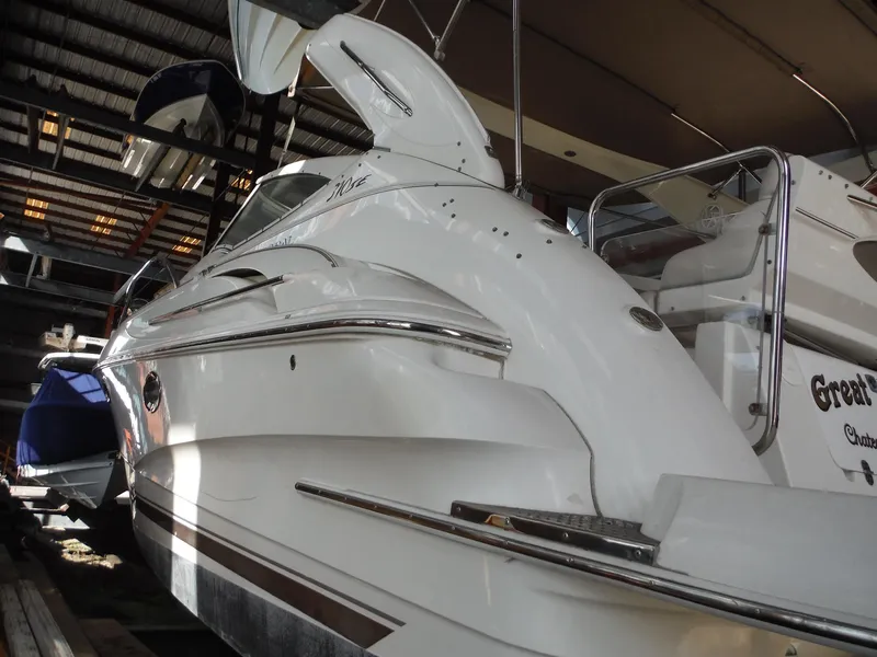Slide: The Image of 2002 Doral 310se boat in storage, sleek white design, indoor marina setting. - 48