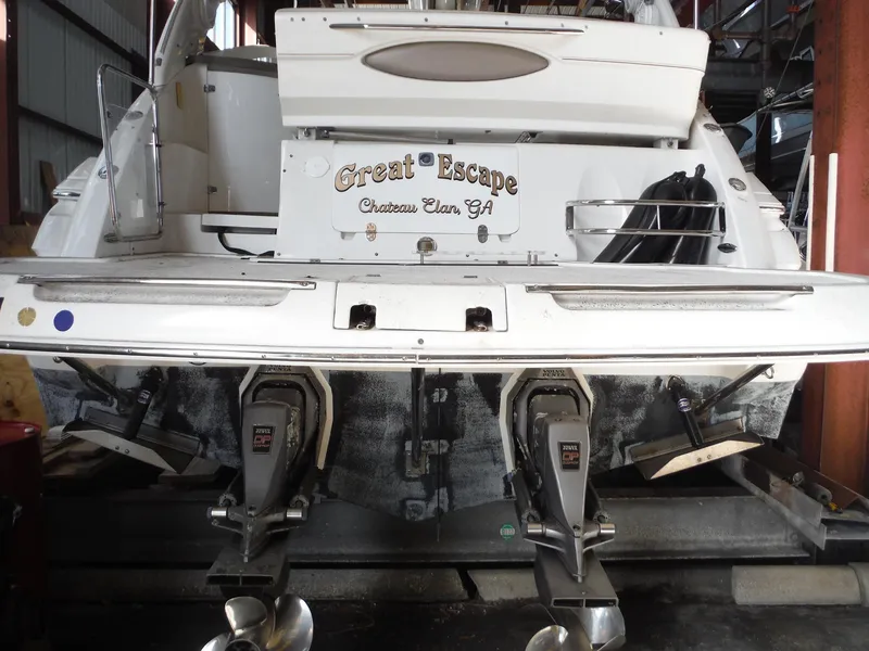 Slide: The Image of 2002 Doral 310se boat "Great Escape" in storage, rear view with dual propellers. - 49
