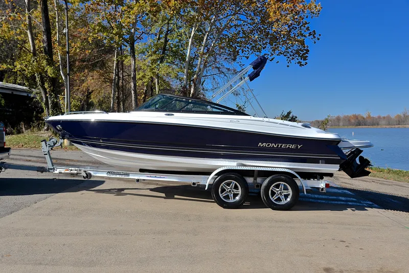 Slide: The Image of 2018 Monterey 204 FS boat on trailer by lakeside, surrounded by autumn trees. - 11