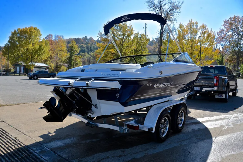 Slide: The Image of 2018 Monterey 204 FS boat on trailer in sunny outdoor setting. - 14