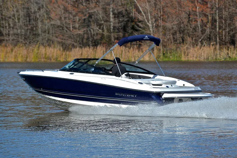 Slide: The Image of 2018 Monterey 204 FS boat cruising on a lake with forest backdrop. - 4
