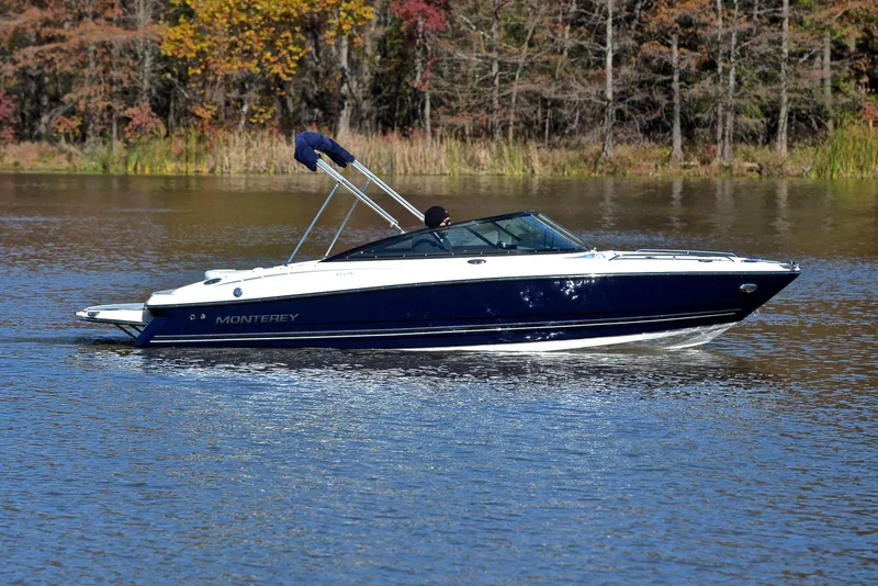 Slide: The Image of 2018 Monterey 204 FS boat cruising on a serene lake with autumn foliage. - 7