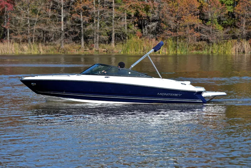 Slide: The Image of 2018 Monterey 204 FS boat cruising on a serene lake with autumn trees. - 9