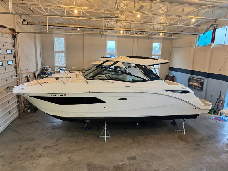The Image of 2019 Sea Ray Sundancer 320 boats in a showroom, showcasing sleek design and luxury features. - 0