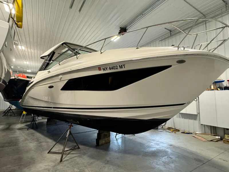 Slide: The Image of 2019 Sea Ray Sundancer 320 yacht interior with seating and table in a showroom. - 2