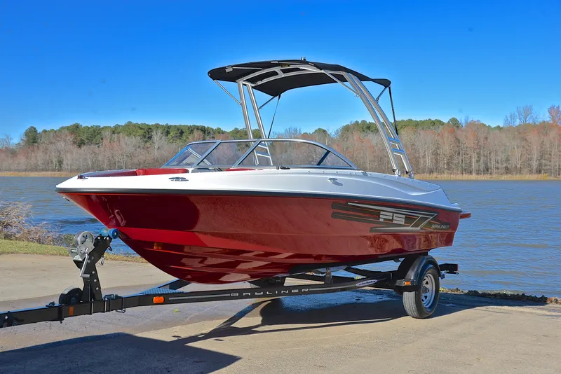Slide: The Image of 2015 Bayliner 195 boat on trailer by a lake, under clear blue sky. - 10