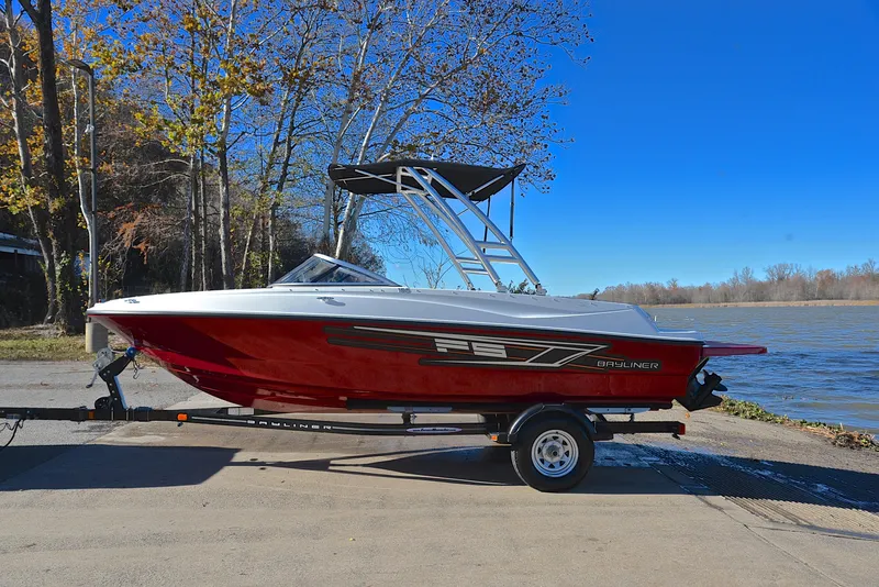 Slide: The Image of 2015 Bayliner 195 boat on trailer by a lake, clear blue sky. - 11