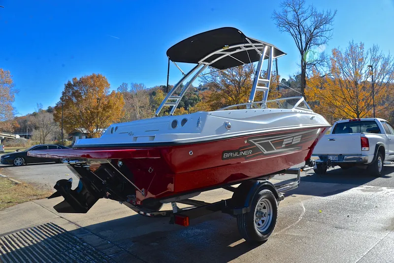 Slide: The Image of 2015 Bayliner 195 boat on trailer, parked outdoors on a sunny day. - 14