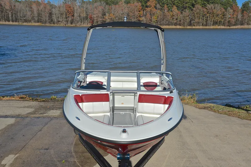 Slide: The Image of 2015 Bayliner 195 boat on a lake, featuring red and white interior. - 17