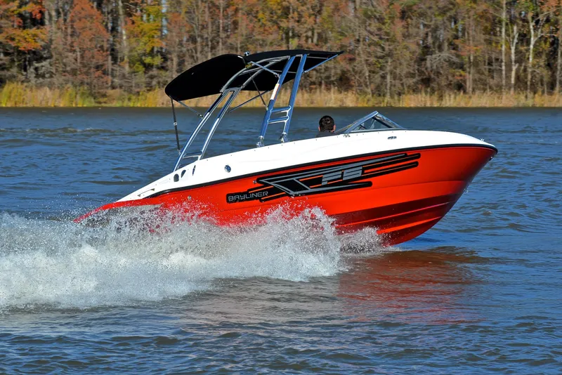 Slide: The Image of 2015 Bayliner 195 boat cruising on a lake with forested background. - 5