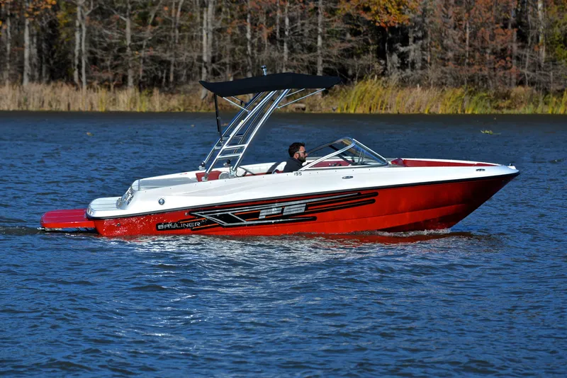 Slide: The Image of 2015 Bayliner 195 boat cruising on a lake with a scenic forest backdrop. - 7