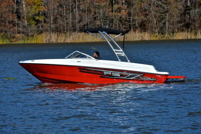 Slide: The Image of 2015 Bayliner 195 boat cruising on a lake with forested background. - 9