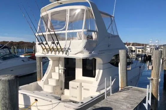 The Image of 2005 Silverton 34 Convertible yacht docked at marina under clear blue sky. - 0