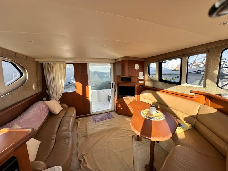 Slide: The Image of Interior of 2005 Silverton 34 Convertible yacht with cozy seating and dining area. - 16