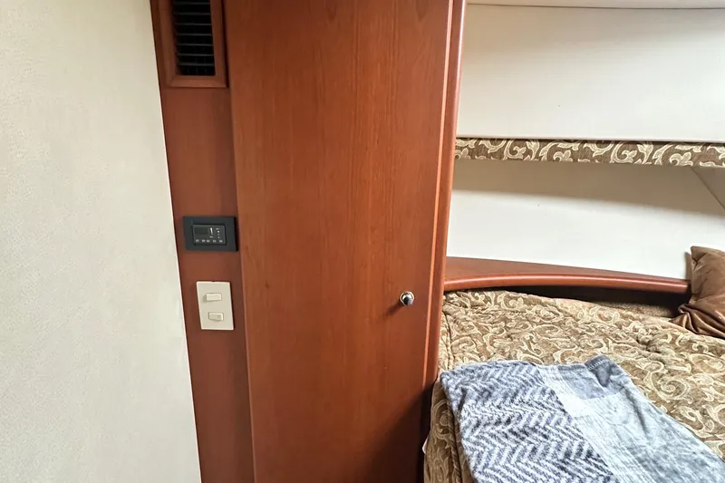 Slide: The Image of Interior of 2005 Silverton 34 Convertible yacht with wood paneling and cozy bedding. - 24
