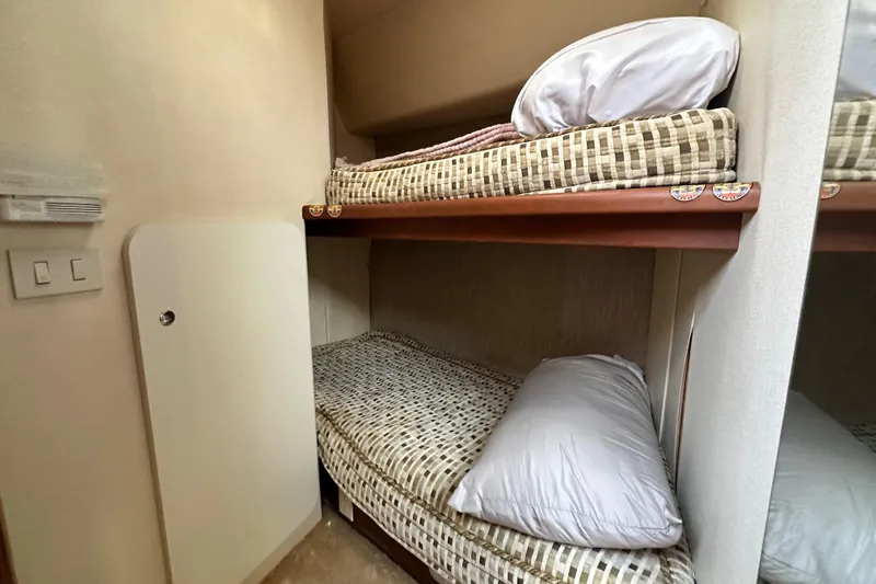 Slide: The Image of 2005 Silverton 34 Convertible yacht interior with cozy bunk beds and pillows. - 26