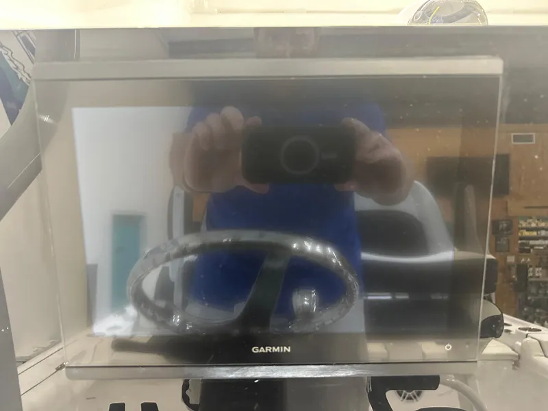 Slide: The Image of Garmin display on 2025 Tidewater 2500CB boat dashboard with steering wheel reflection. - 10