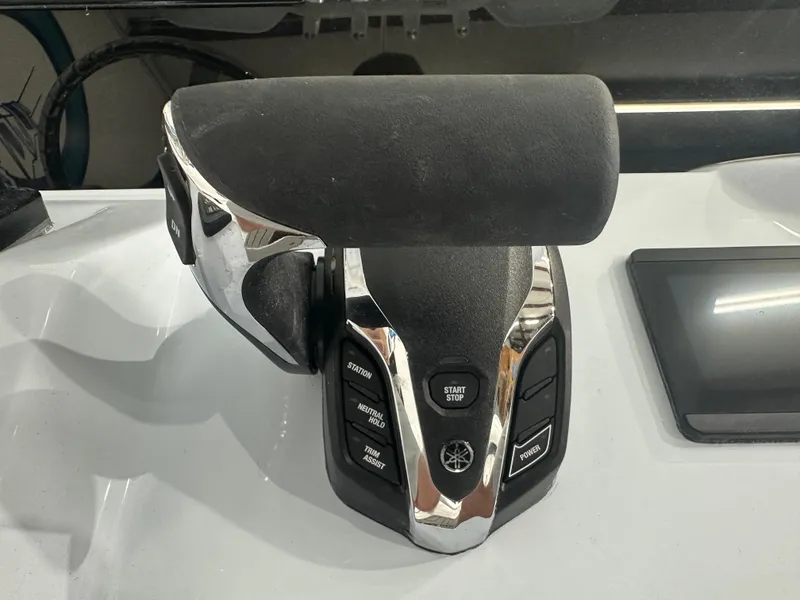 Slide: The Image of Close-up of 2025 Tidewater 2500CB boat throttle control with buttons and display. - 14
