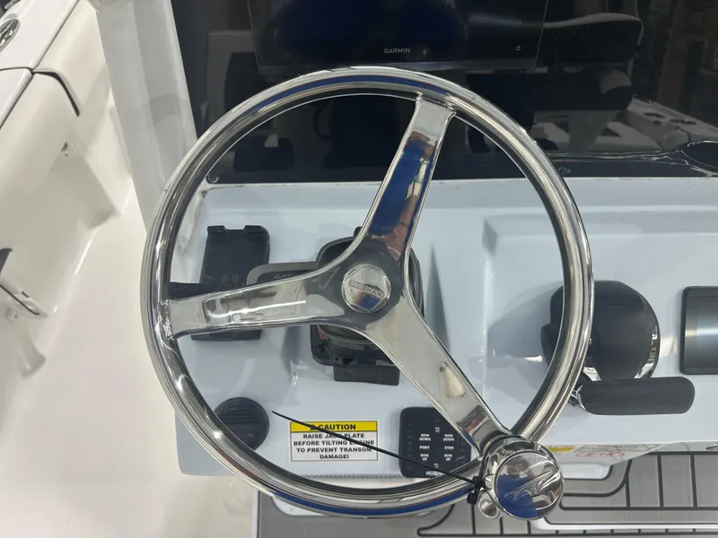 Slide: The Image of 2025 Tidewater 2500CB boat steering wheel and control panel. - 16