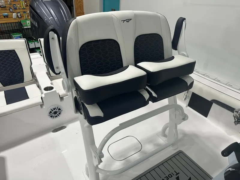 Slide: The Image of 2025 Tidewater 2500CB boat interior with dual cushioned seats and Yamaha engine. - 19